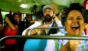 Photo de la vidéo de la chanson La Guagua qui utilise un mélange de son rap et guaracha avec des paroles d’humour noir pour commenter les faiblesses du système social. Chanson extraite de l’album A son de Guerra.