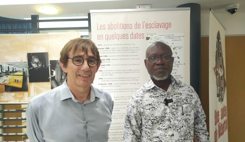Le directeur des archives départementales de Guadeloupe, Benoît Jullien (à gauche, accueille le 29 mai 2024 Bertin Calixte Biah (à droite), directeur du musée d’histoire de Ouidah au Bénin, lors d'une visite des archives à Bisdary, Gourbeyre. Photo : X Véronique Parmentier DR