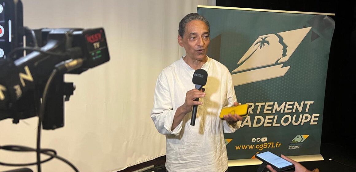 Serge Romana, président du Comité de la marche du 23 mai 1998 et coprésident du comité de pilotage du futur Mémorial national des noms des victimes de l’esclavage colonial, présente le 23 décembre 2025 au Mémorial Acte à Pointe-à-Pitre, les plans architecturaux et paysagers du projet. Photo : Le Courrier de Guadeloupe Serge Romana, président du Comité de la marche du 23 mai 1998 et coprésident du comité de pilotage du futur Mémorial national des noms des victimes de l’esclavage colonial, présente le 23 décembre 2025 au Mémorial Acte à Pointe-à-Pitre, les plans architecturaux et paysagers du projet. Photo : Le Courrier de Guadeloupe