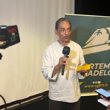 Serge Romana, président du Comité de la marche du 23 mai 1998 et coprésident du comité de pilotage du futur Mémorial national des noms des victimes de l’esclavage colonial, présente le 23 décembre 2025 au Mémorial Acte à Pointe-à-Pitre, les plans architecturaux et paysagers du projet. Photo : Le Courrier de Guadeloupe